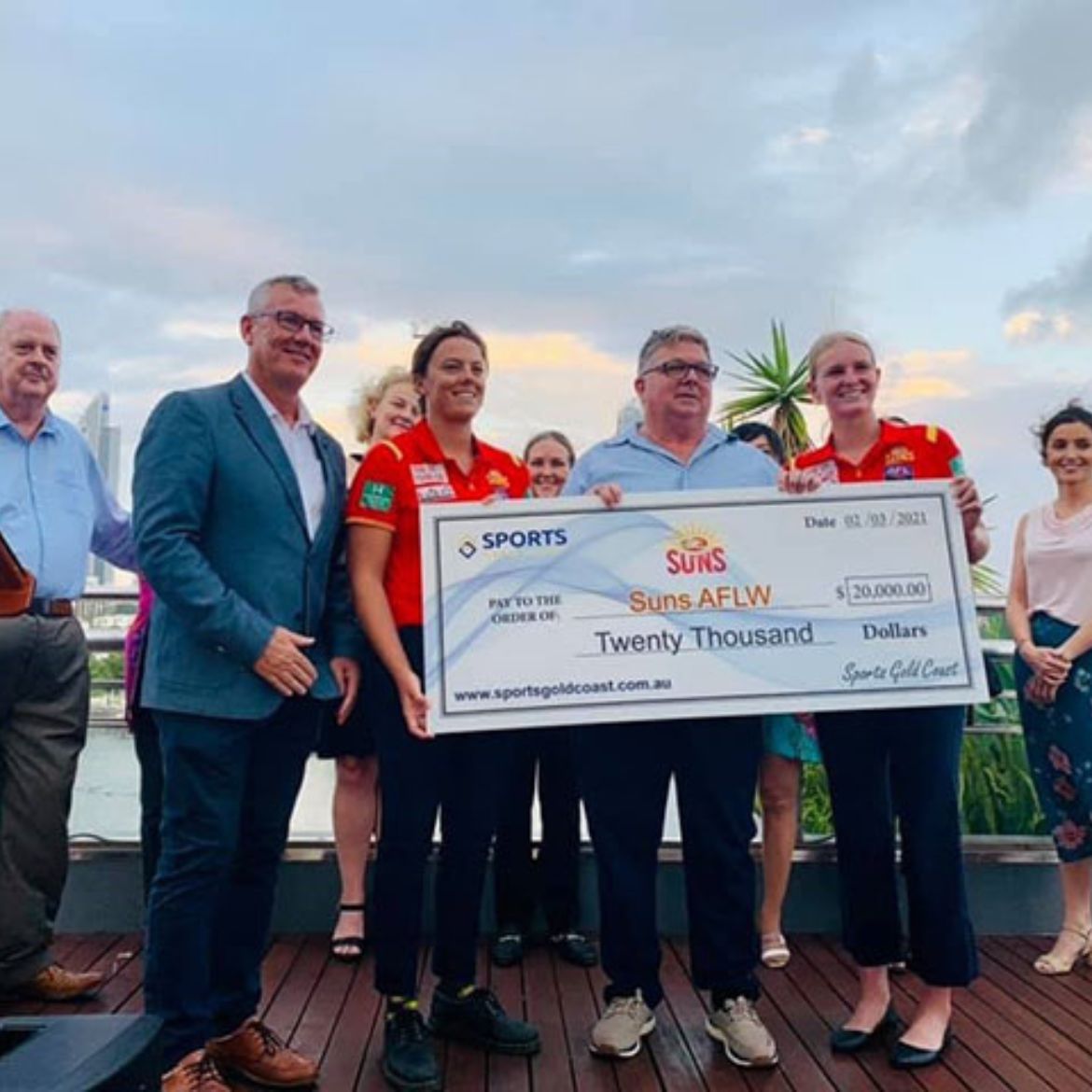 Garry Goodman on behalf of Sports Gold Coast representing the Suns AFLW players with a cheque for sponsorship
