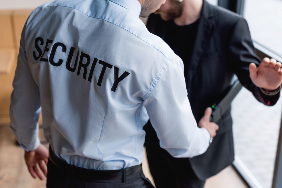 Security guard using metal detector