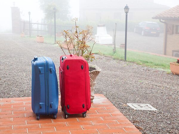 Suitcases packed and ready to go on holiday waiting at front door step of property.